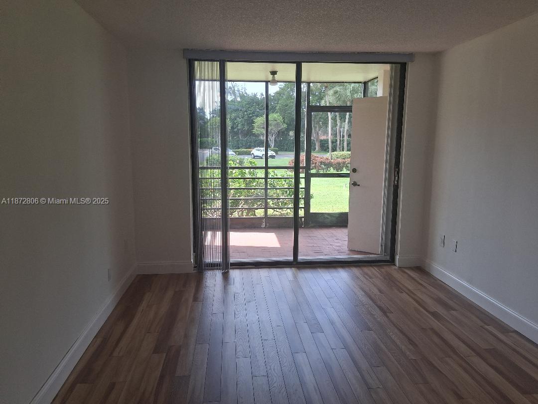 1000 St Charles Place, Unit L20 Pembroke Pines, FL 33026 - Photo 11 of 23 wooden floor in an empty room with a window