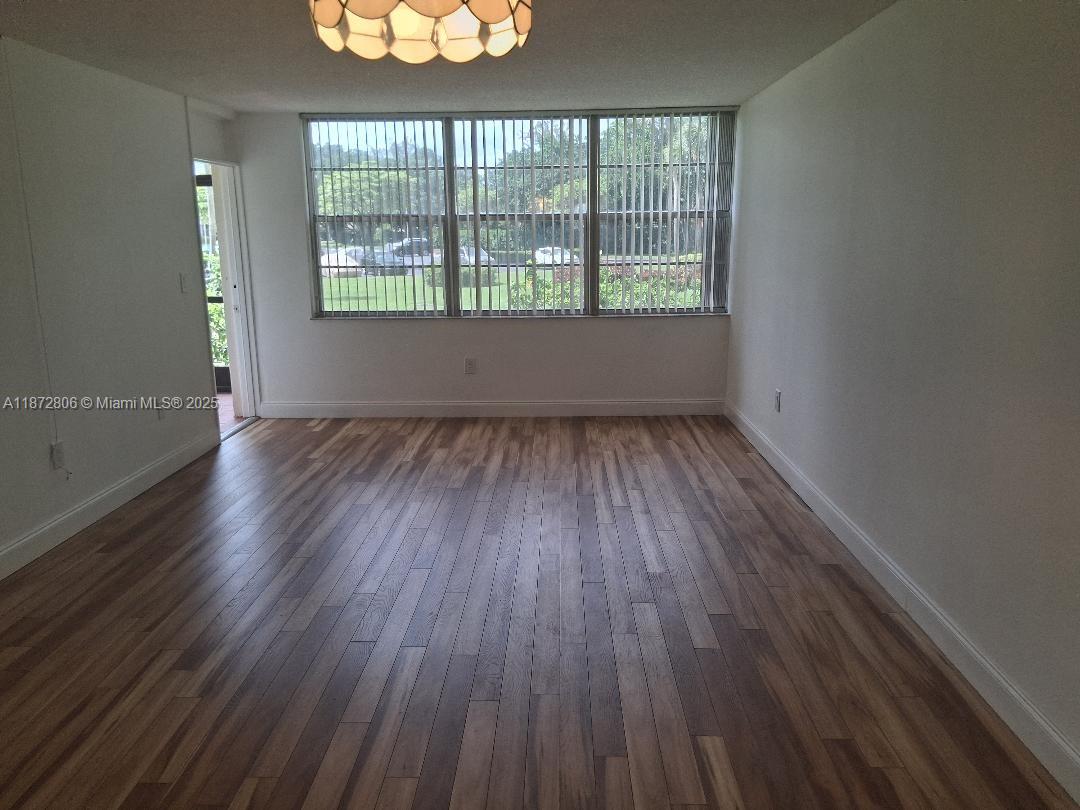 1000 St Charles Place, Unit L20 Pembroke Pines, FL 33026 - Photo 10 of 23 an empty room with wooden floor and windows