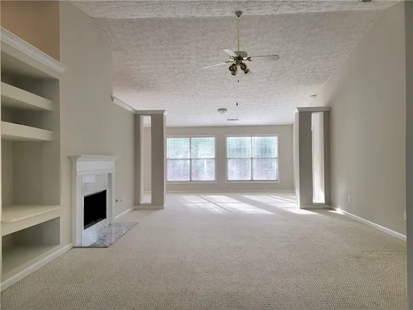 a view of an empty room with a fireplace and a window