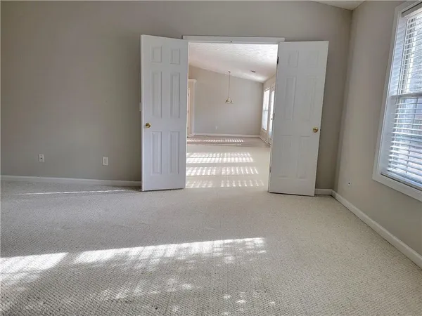 an empty room with windows and closet