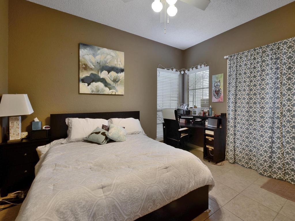 3001 Cedar Street, Unit 117 Austin, TX 78705 - Photo 13 of 20 a bedroom with a bed and a lamp on dresser