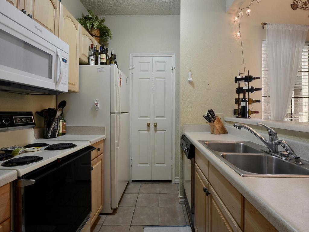 3001 Cedar Street, Unit 117 Austin, TX 78705 - Photo 16 of 20 a kitchen that has a sink a stove and cabinets