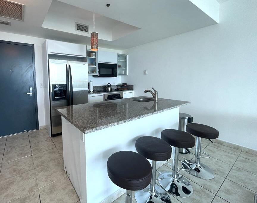888 Biscayne Boulevard, Unit 811 Miami, FL 33132 - Photo 10 of 33 a kitchen with stainless steel appliances granite countertop a sink a stove a microwave a refrigerator and chairs