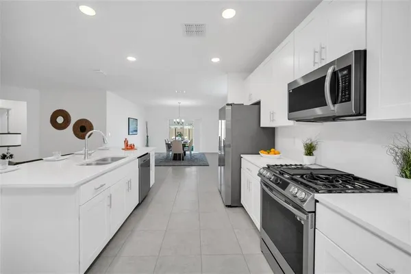 a kitchen with stainless steel appliances a sink dishwasher stove microwave and cabinets