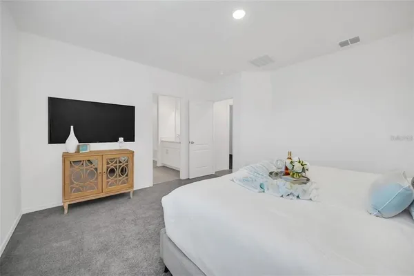 a bedroom with a bed and flat screen tv