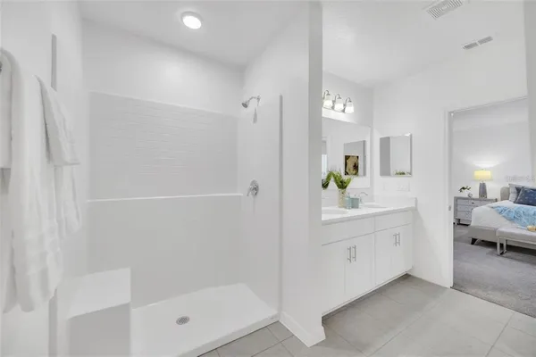 a en suite bathroom with a shower sink and mirror