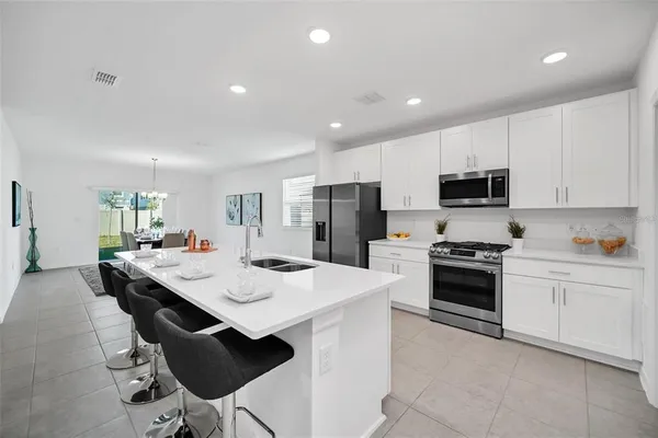 a large kitchen with kitchen island a sink a stove a table and chairs