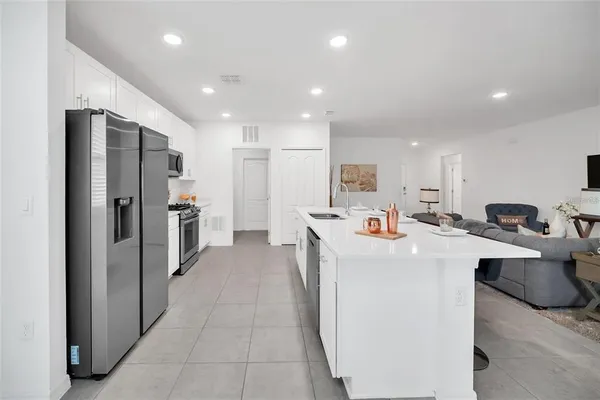 a large white kitchen with lots of counter space and stainless steel appliances