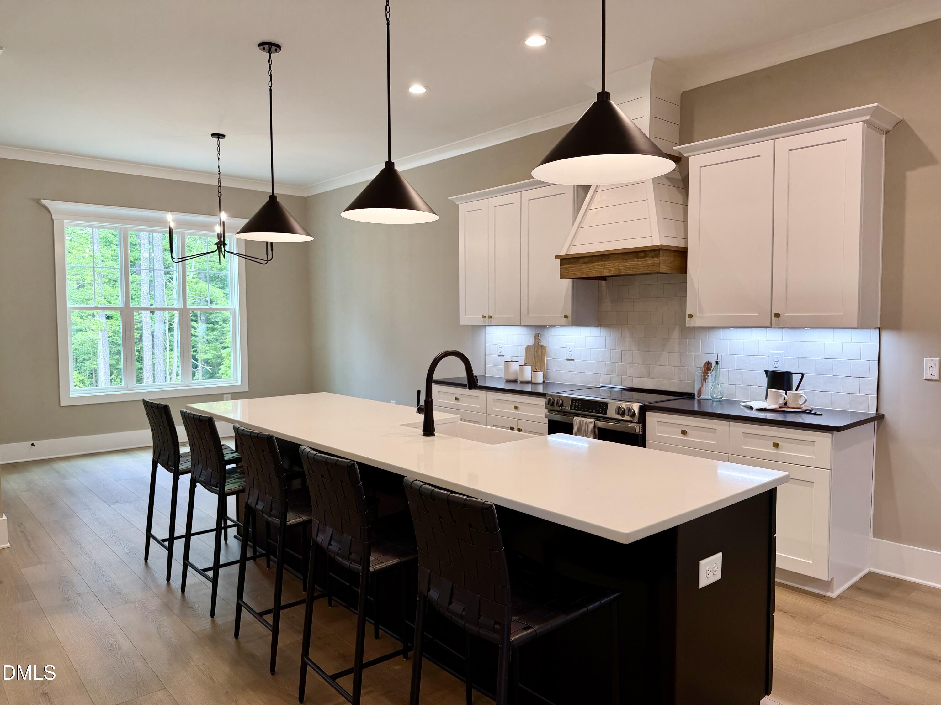 2590 Lassiter Road Four Oaks, NC 27524 - Photo 16 of 72 a kitchen with a stove a sink a dining table and chairs