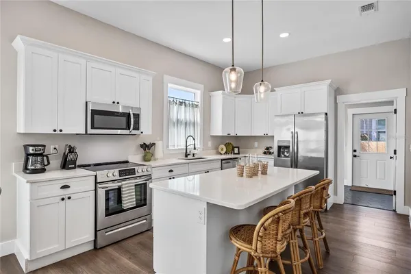 a kitchen with a stove a sink and a refrigerator