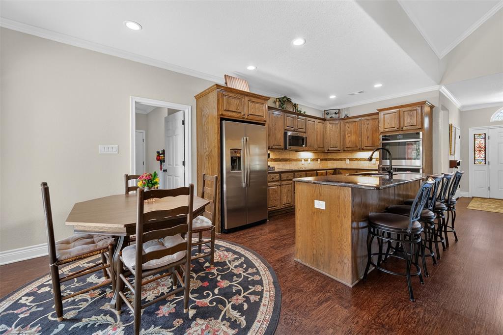 403 Arrowhead Point Kerens, TX 75144 - Photo 11 of 40 a kitchen with stainless steel appliances a table chairs refrigerator and chairs