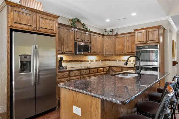a kitchen with kitchen island a counter top space appliances and cabinets