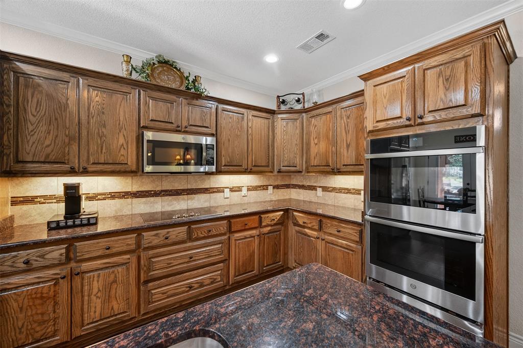 403 Arrowhead Point Kerens, TX 75144 - Photo 15 of 40 a kitchen with granite countertop a sink stove and microwave