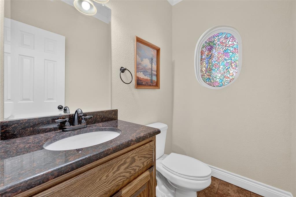 403 Arrowhead Point Kerens, TX 75144 - Photo 31 of 40 a bathroom with a granite countertop toilet a sink and a mirror