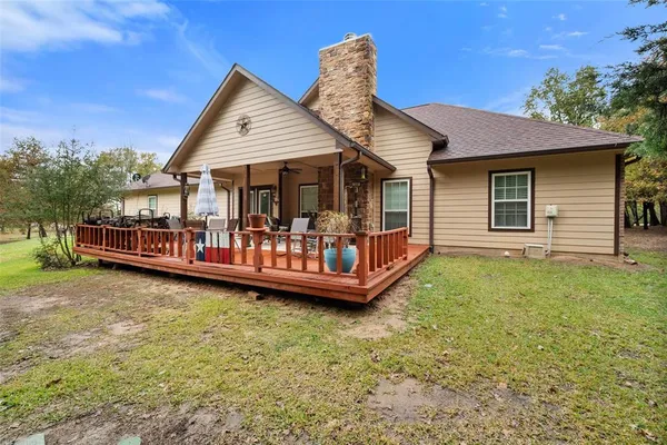 a view of a house with a backyard and deck