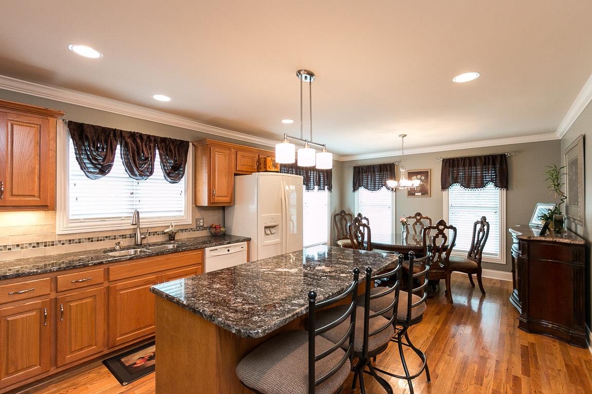 1232 Sugar Flat Road Lebanon, TN 37087 - Photo 14 of 30 a kitchen with granite countertop a table chairs stove and wooden floor
