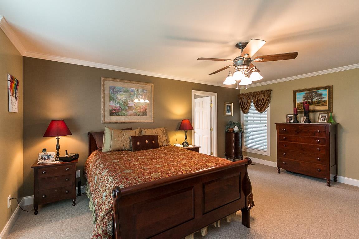1232 Sugar Flat Road Lebanon, TN 37087 - Photo 19 of 30 a bedroom with a bed and a chandelier