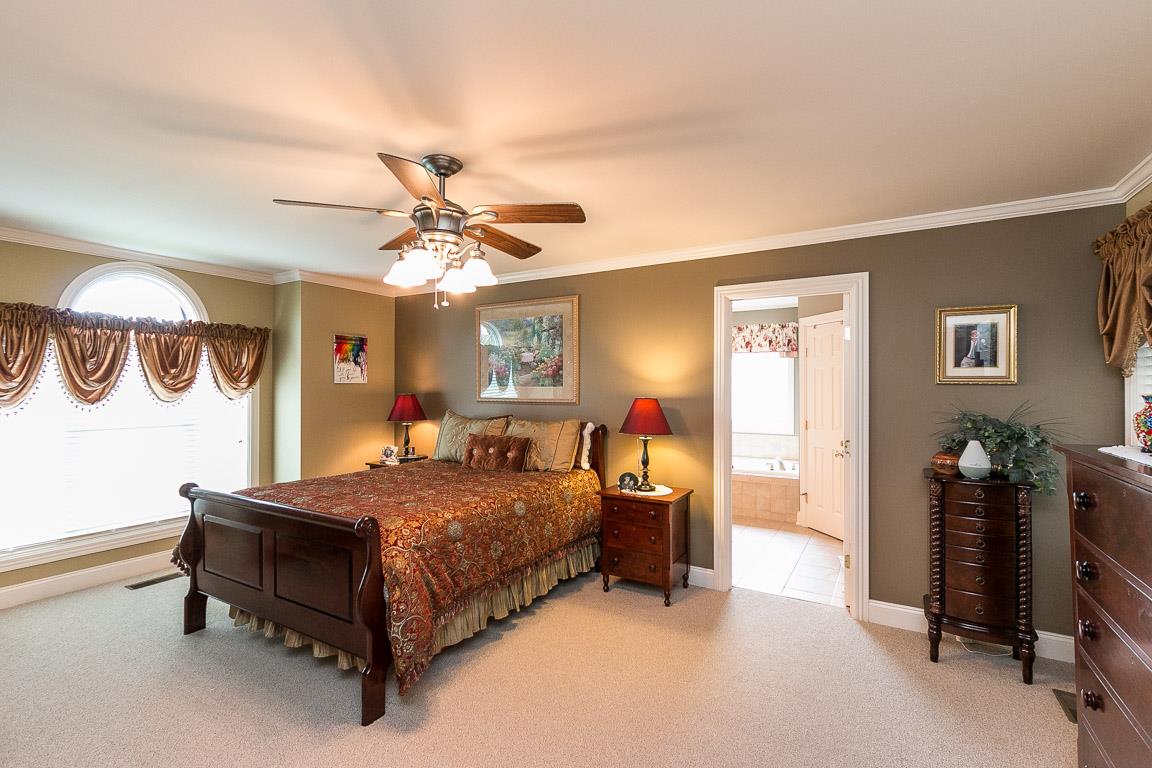 1232 Sugar Flat Road Lebanon, TN 37087 - Photo 20 of 30 a bedroom with a bed and a chandelier