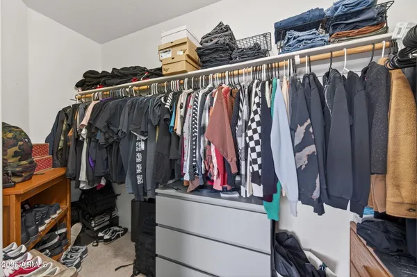 a view of walk in closet with clothes and shoes
