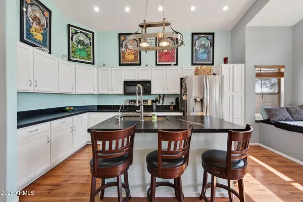 a kitchen with stainless steel appliances a table chairs and a refrigerator