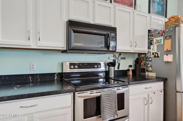 a kitchen with stainless steel appliances granite countertop a stove a microwave and cabinets