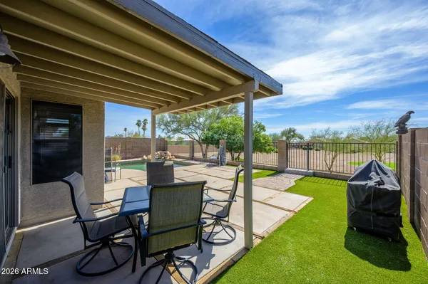 a view of a swimming pool with a table and chairs under an umbrella