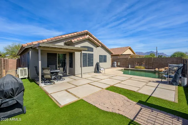 a view of a backyard with couches plants and large tree