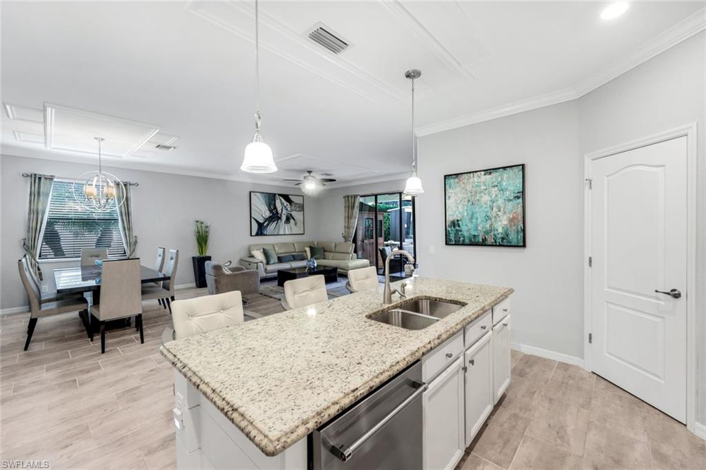 4244 Raffia Palm Circle Naples, FL 34119 - Photo 11 of 38 a kitchen with a sink a counter space and living room view