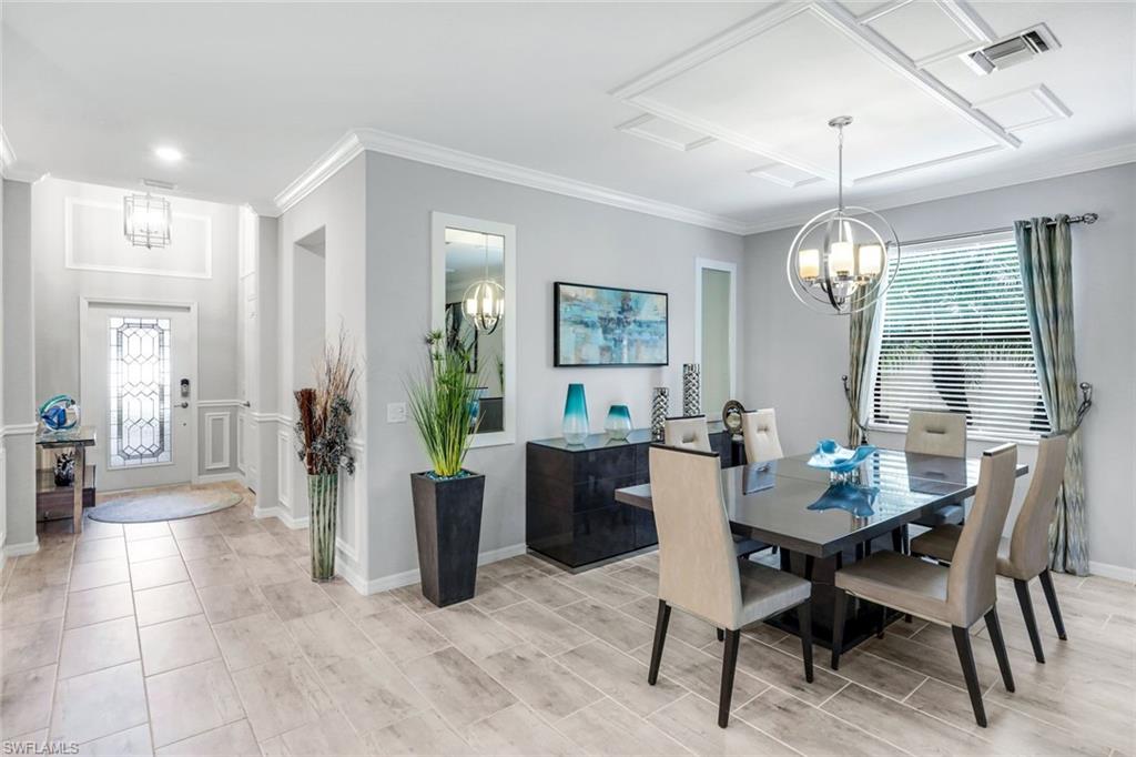4244 Raffia Palm Circle Naples, FL 34119 - Photo 12 of 38 a view of a dining room with furniture window and wooden floor