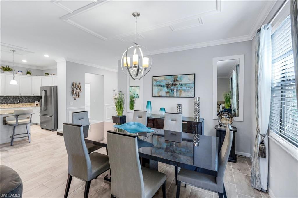 4244 Raffia Palm Circle Naples, FL 34119 - Photo 13 of 38 a view of a dining room with furniture window and wooden floor