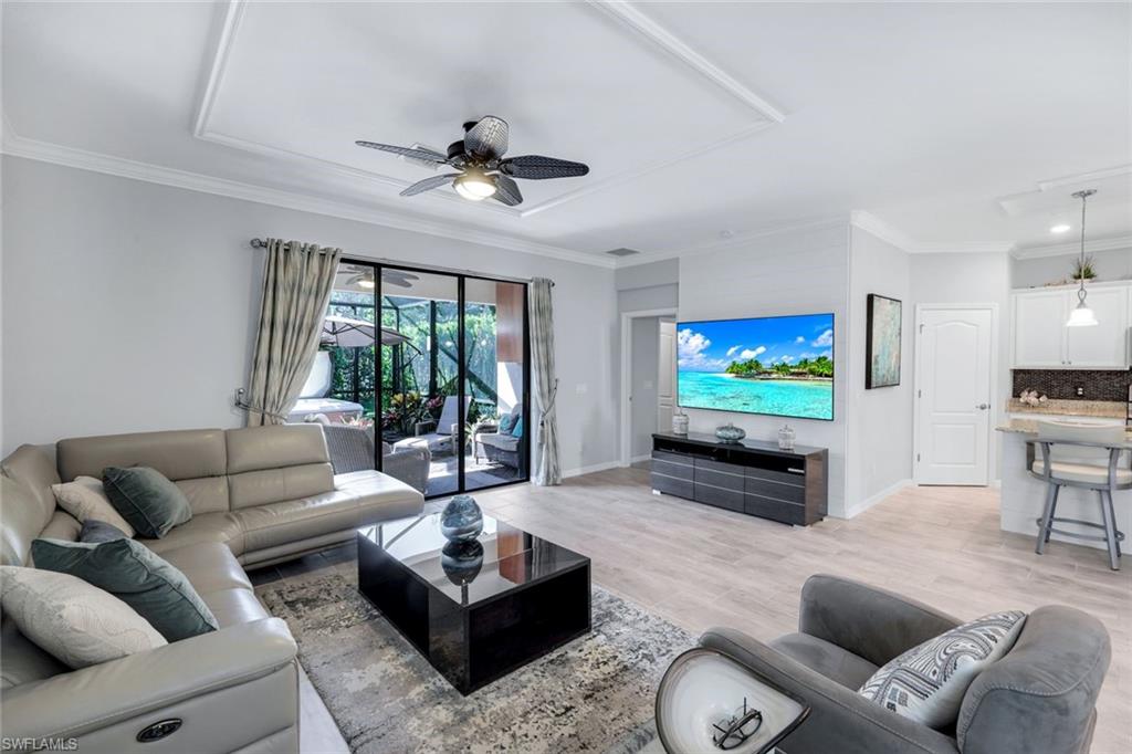 4244 Raffia Palm Circle Naples, FL 34119 - Photo 15 of 38 a living room with furniture and a flat screen tv