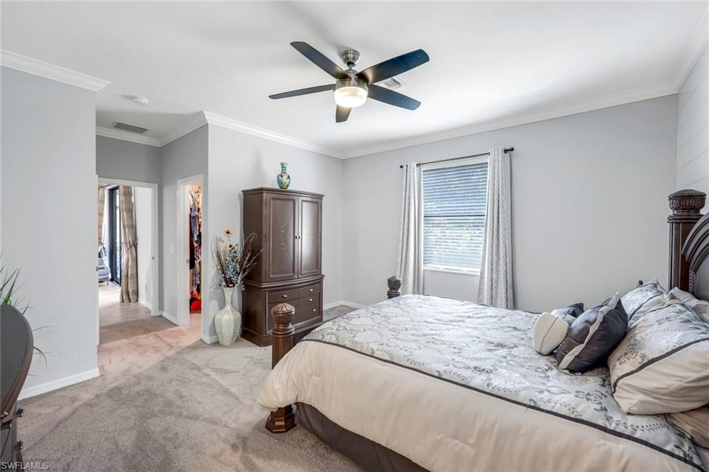 4244 Raffia Palm Circle Naples, FL 34119 - Photo 18 of 38 a bedroom with a bed and ceiling fan