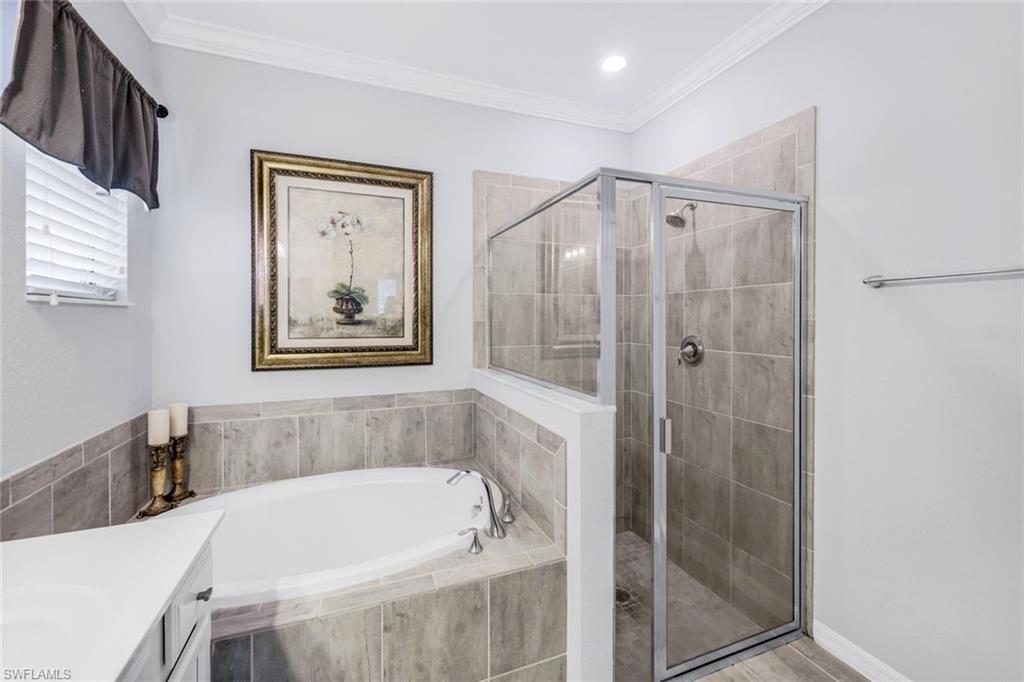 4244 Raffia Palm Circle Naples, FL 34119 - Photo 20 of 38 a bathroom with a tub and shower