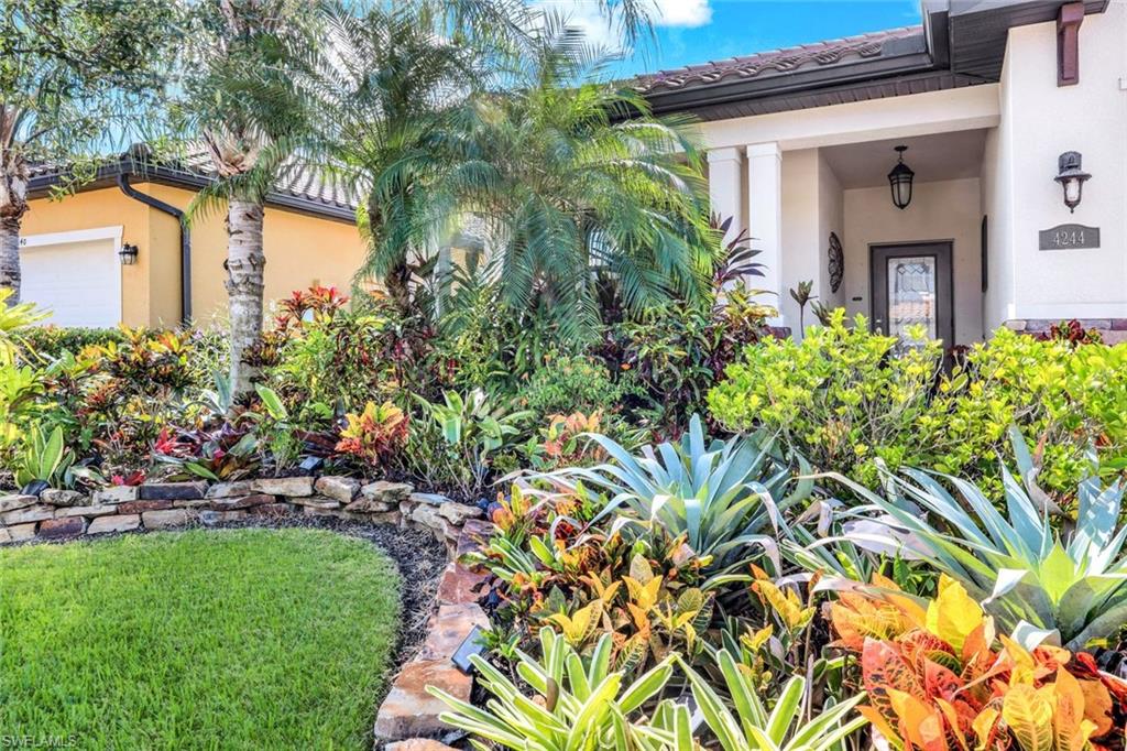4244 Raffia Palm Circle Naples, FL 34119 - Photo 3 of 38 a front view of a house with a garden