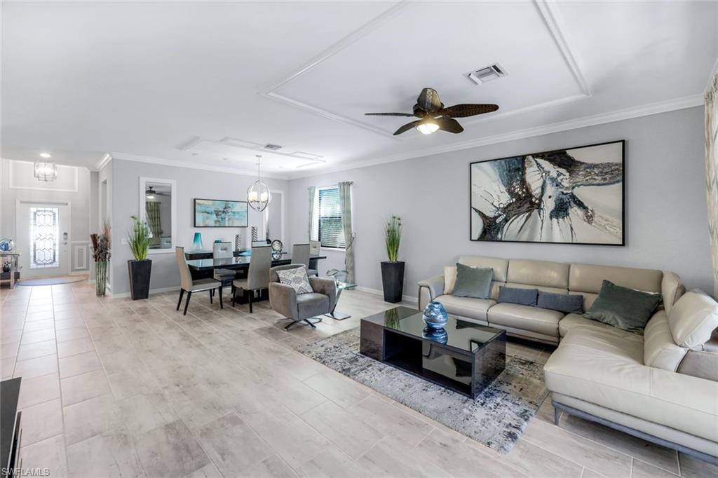 4244 Raffia Palm Circle Naples, FL 34119 - Photo 5 of 38 a living room with furniture and a chandelier