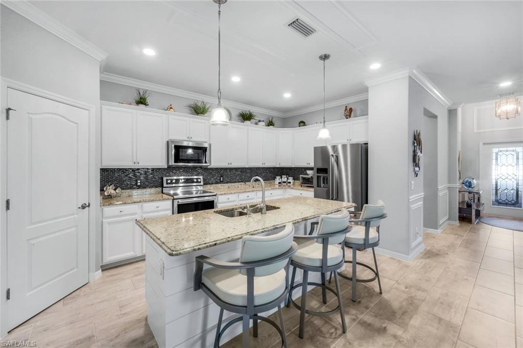 4244 Raffia Palm Circle Naples, FL 34119 - Photo 8 of 38 a large kitchen with a table and chairs in it