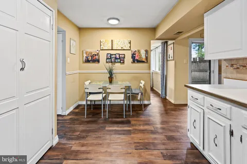 a kitchen with stainless steel appliances a dining table chairs and granite counter tops