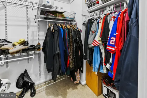 a view of walk in closet with clothes and shoes