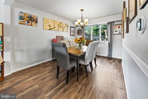 a dining room with furniture a chandelier and wooden floor