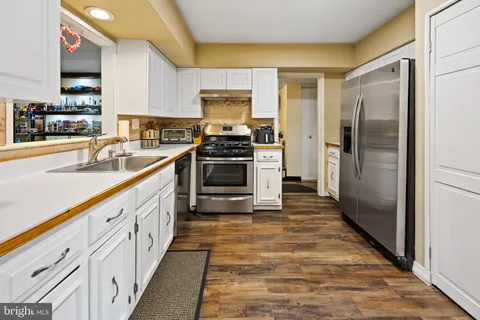 a kitchen with granite countertop a refrigerator and a sink