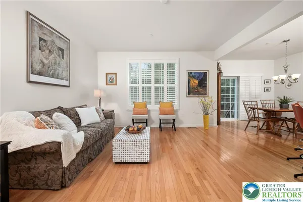 a view of a dining room with furniture a chandelier and wooden floor