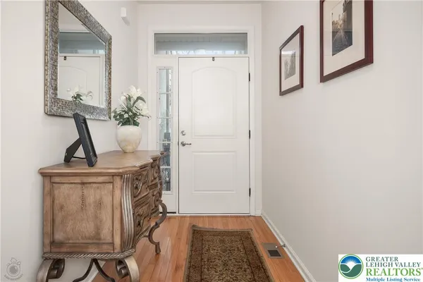a living room with furniture a potted plant and a wooden floor