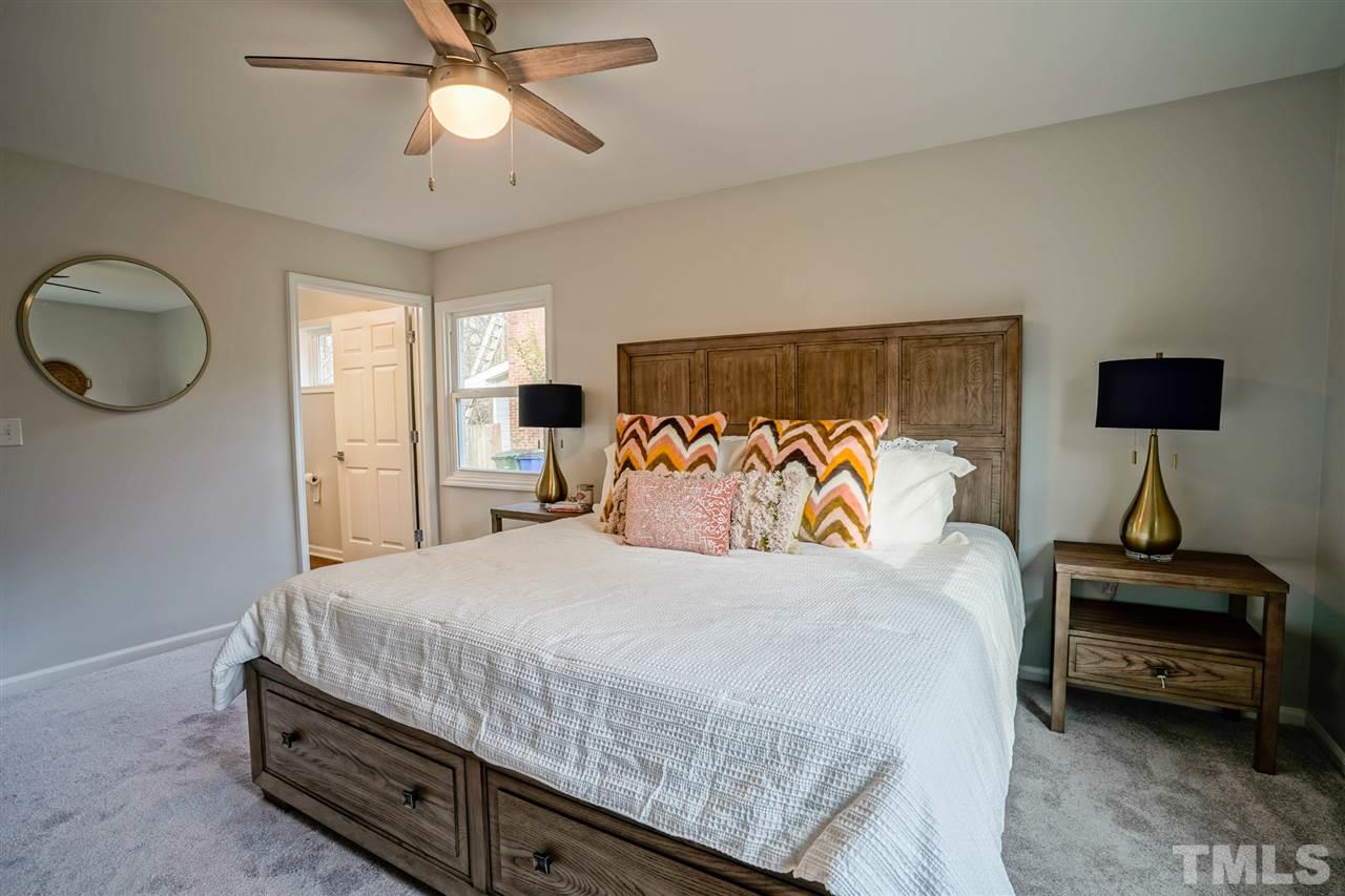 1105 Paddock Drive Raleigh, NC 27609 - Photo 21 of 30 a bedroom with a bed and a chandelier