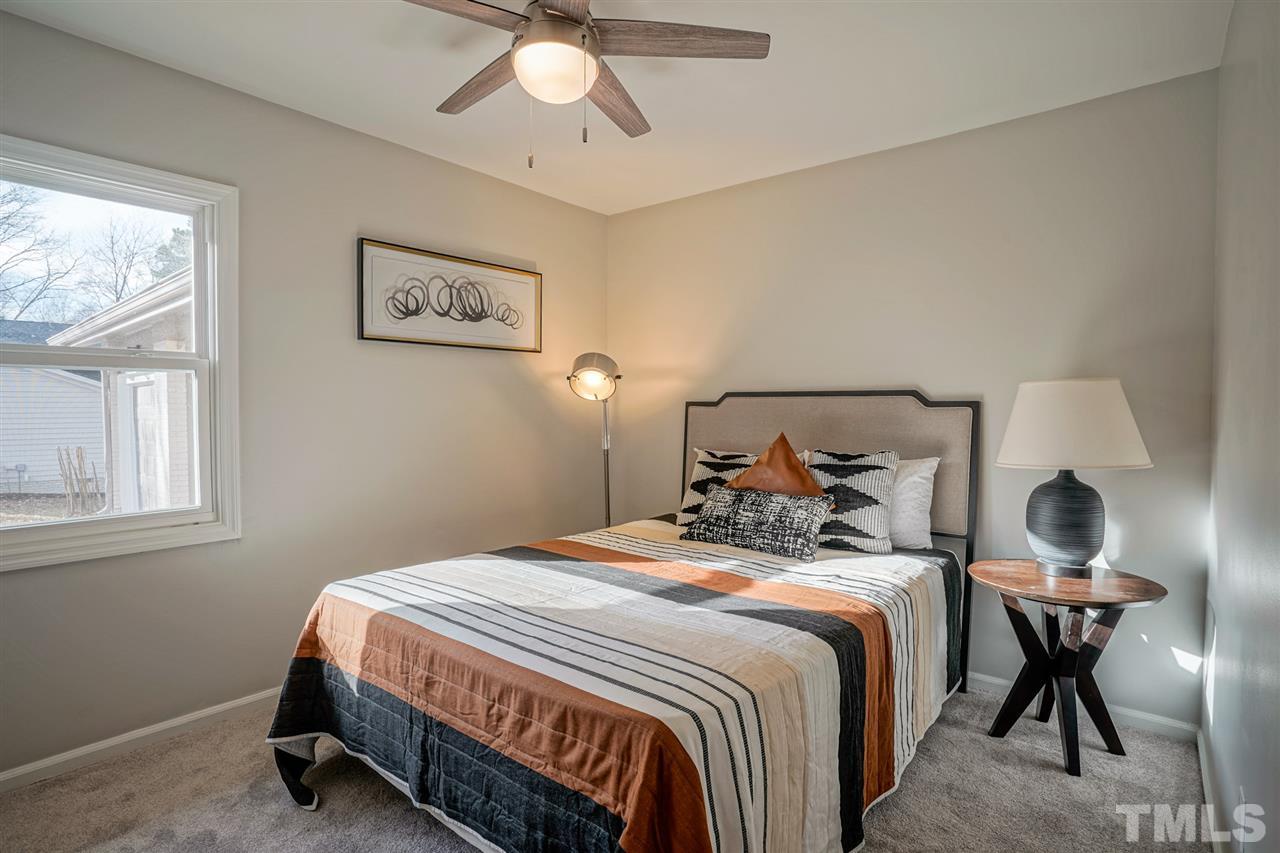 1105 Paddock Drive Raleigh, NC 27609 - Photo 27 of 30 a bedroom with a bed and a chandelier