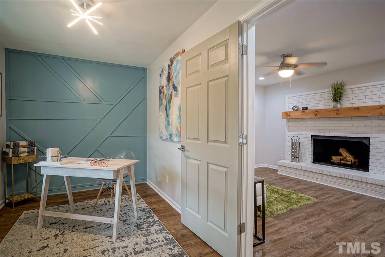 1105 Paddock Drive Raleigh, NC 27609 - Photo 7 of 30 a room with furniture a fireplace and wooden floor