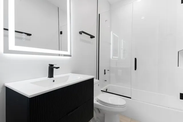 a bathroom with a sink a toilet and shower