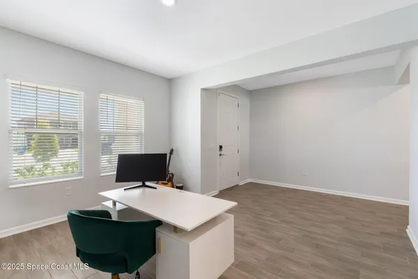 a view of a workspace with furniture and wooden floor