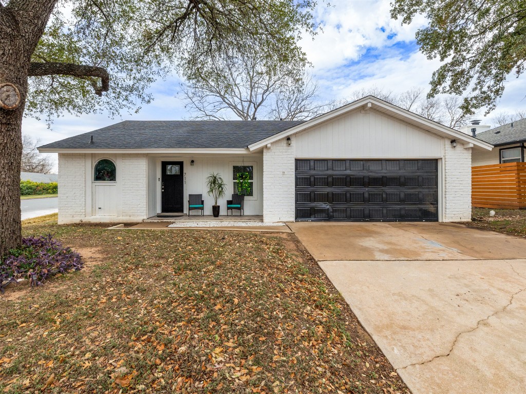 Single story home with brick siding, covered porch, concrete driveway, roof with shingles, and a garage