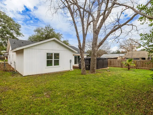 a view of a yard with a house and a large tree