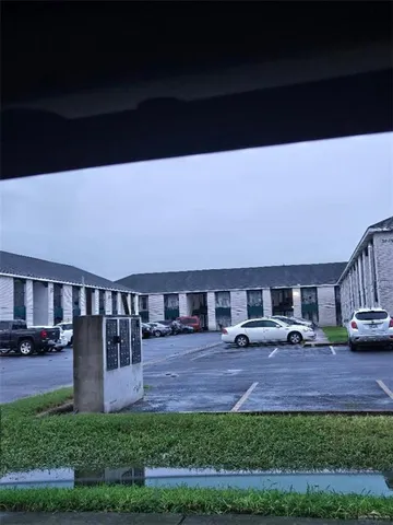 a view of house with yard and car parked